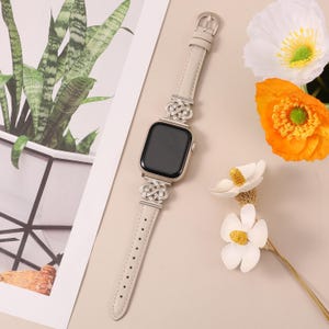 Celtic knot apple watch band in cream white leather with silver hardware, styled for elegant daily wear