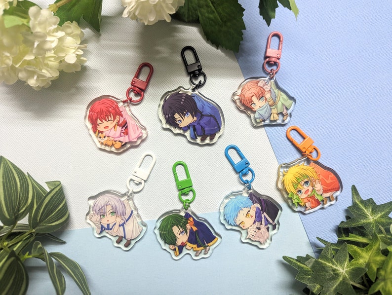 May include: Seven colorful anime character keychains with different characters and designs. Each keychain features a clear acrylic charm with a colorful anime character illustration and a metal ring.