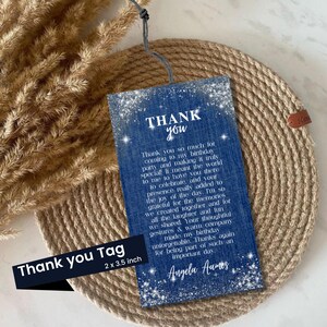 Puede incluir: Una etiqueta azul con las palabras "THANK YOU" en blanco, junto con un mensaje personalizado. La etiqueta mide 5,08 x 8,89 cm y tiene una cuerda adjunta. La etiqueta est&aacute; sobre una superficie circular tejida.