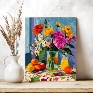 Może przedstawiać: Martwa natura przedstawiająca biały wazon z suchą trawą i kolorową kompozycją kwiatową w szklanym wazonie. Pomarańcze i mały dzbanek soku leżą na kwiecistym obrusie. Tło to niebieska ściana.