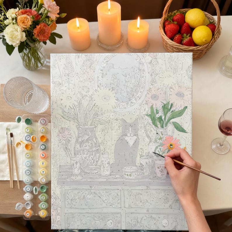 A person is painting a picture of a cat sitting on a table with various objects, such as vases, flowers, and a bowl, in front of them.