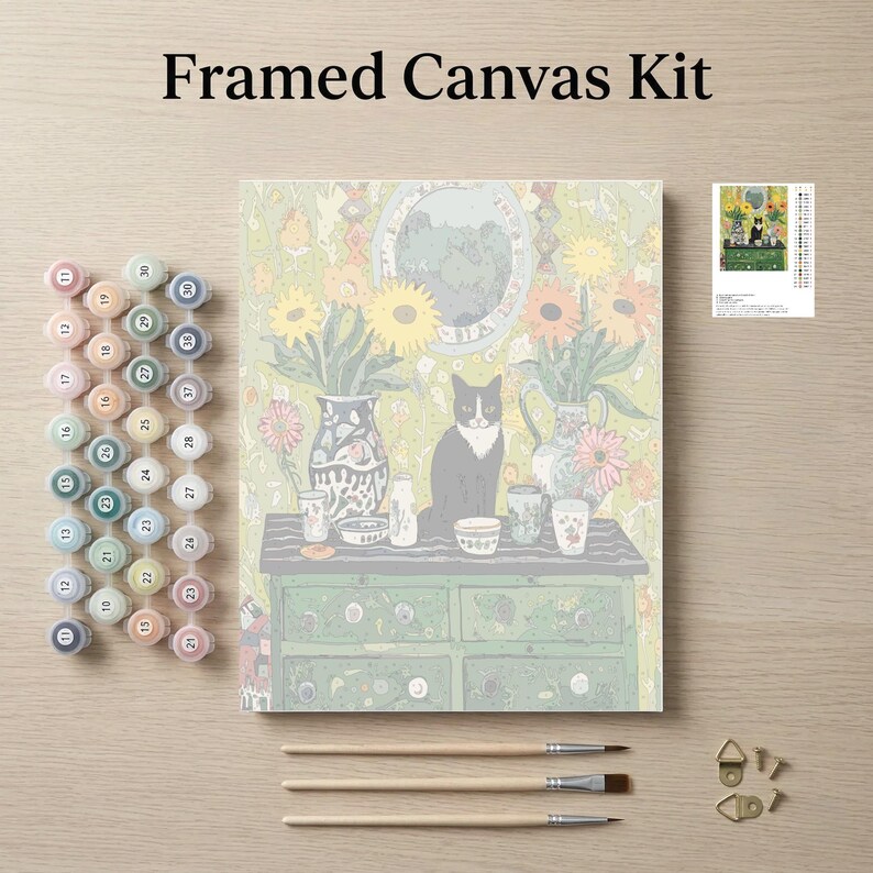 The image is a framed canvas kit featuring a painting of a cat sitting on a table surrounded by various objects, such as vases, cups, and a clock. The kit also includes paintbrushes, paint tubes, and a small picture frame.