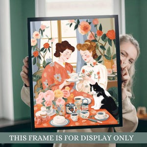 a woman holding up a picture of two women and a cat
