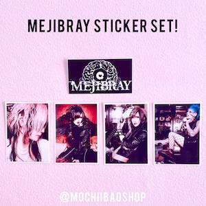 Puede incluir: Un juego de pegatinas con la banda MEJIBRAY. El juego incluye cuatro pegatinas con retratos de los miembros de la banda y una pegatina con el logotipo. Las pegatinas se muestran sobre un fondo rosa con el texto "MEJIBRAY STICKER SET!" y el nombre de Instagram de la tienda.