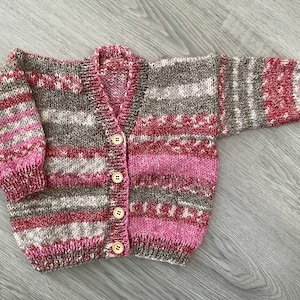 Hand knitted baby cardigan in Pinks & Browns.