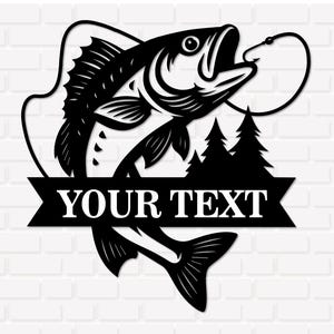 May include: Black metal wall art featuring a largemouth bass jumping towards a fishing hook. The design includes two pine trees and a banner with the text "YOUR TEXT". The artwork is set against a white brick background.