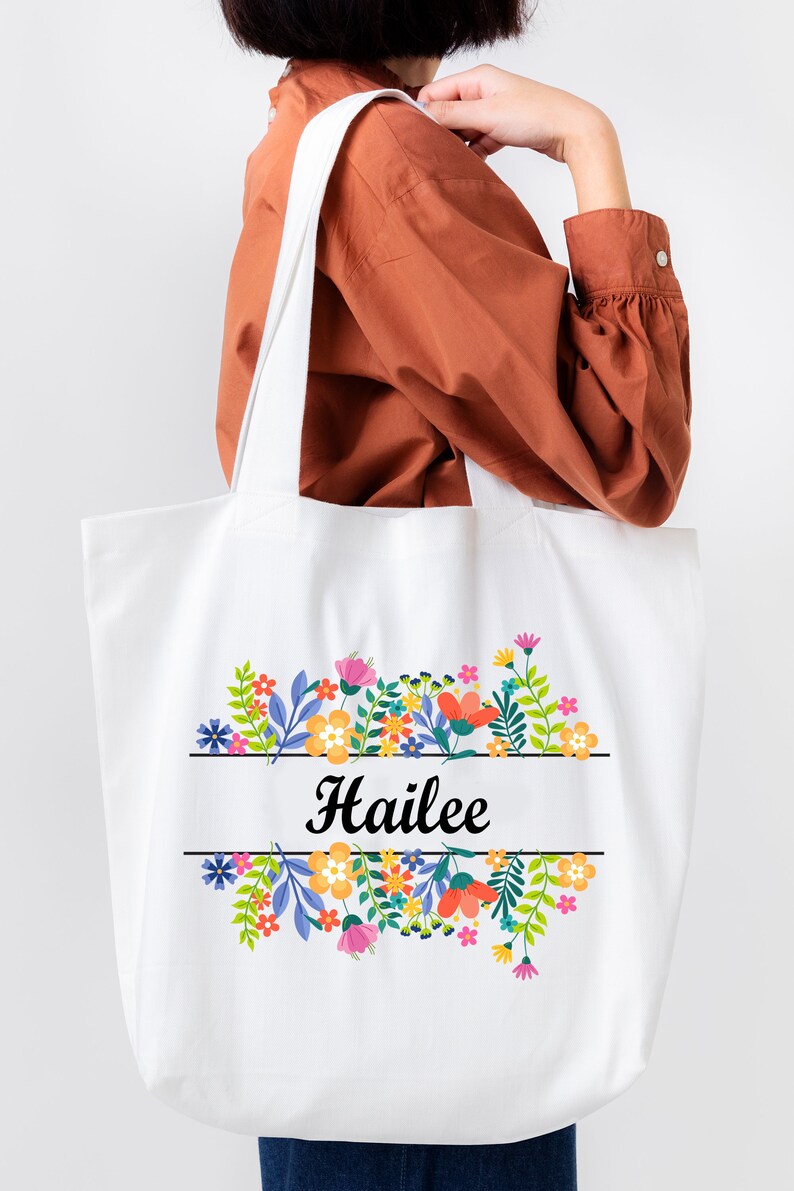 May include: White tote bag with a floral design and the name "Hailee" printed in black.