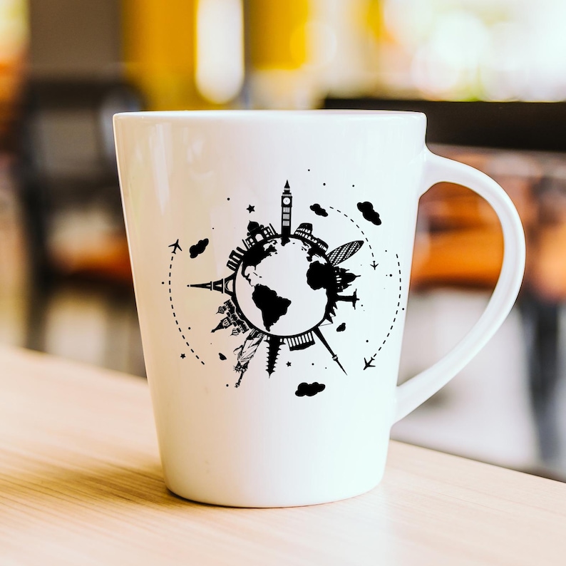 May include: White ceramic mug with a black and white design of the world with famous landmarks around it. The mug has a handle on the right side.