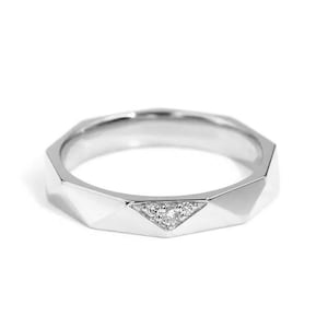 Könnte beinhalten: Ein silberner Ring mit geometrischem Design. Der Ring hat eine Reihe von Facetten und eine dreieckige Fassung aus kleinen, klaren Edelsteinen. Der Ring ist vor einem weißen Hintergrund platziert.