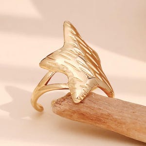 May include: Gold-toned adjustable ring featuring a textured star design.