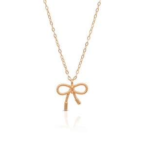 May include: A gold necklace featuring a dainty bow pendant. The bow is crafted from twisted wire and has a simple, elegant design.