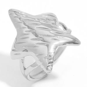 May include: A silver ring with a textured star design. The star is three-dimensional and has a slightly curved shape.