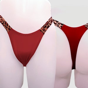 Puede incluir: Lingerie roja con ribete de estampado de leopardo. La lencería se muestra en un maniquí blanco.
