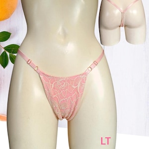 Peut inclure: Lingerie en dentelle rose avec des bretelles réglables et un motif floral. La lingerie est présentée sur un mannequin.