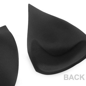 Puede incluir: Dos insertos de sujetador negros, uno con la palabra "BACK" impresa en el fondo blanco.