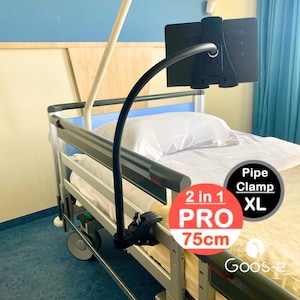 May include: A black tablet holder with a flexible arm attached to a large clamp. The clamp is attached to a white hospital bed rail. The holder is labeled "2 in 1 PRO 75cm" and "Pipe Clamp XL".