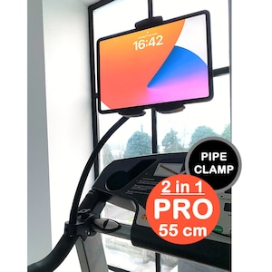 May include: A black tablet holder with a long, flexible arm attached to a black pipe clamp. The tablet holder is mounted on a treadmill and is holding a tablet with a bright orange and blue screen. The text "2 in 1 PRO 55 cm" is visible on the image.