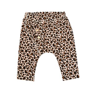 Peut inclure: Pantalon bébé imprimé léopard avec un bouton marron sur le devant.