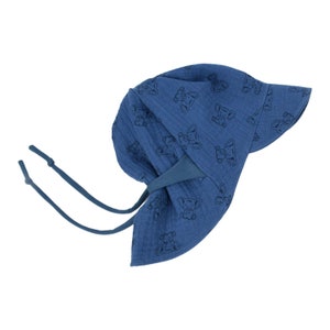 Può includere: Un cappello da sole blu con una piccola stampa di elefante. Il cappello ha un'ampia tesa e una cravatta che può essere legata sotto il mento.