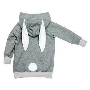 Könnte beinhalten: Grauer Kapuzenpullover mit weißen Hasenohren und einem weißen Schwanz auf der Rückseite.