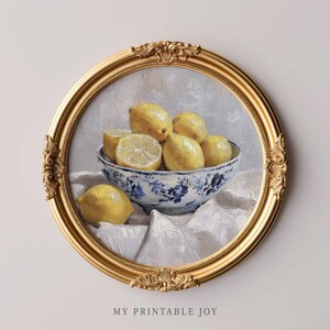 May include: A painting of a bowl of lemons in a blue and white porcelain bowl. The bowl is sitting on a white cloth. The lemons are yellow and have a glossy finish. The painting is framed in a gold frame.