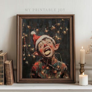 May include: A framed print featuring a whimsical elf wearing a Santa hat, with a cookie in their mouth, and string lights. The artwork has a vintage aesthetic, with the text "MY PRINTABLE JOY" at the top.