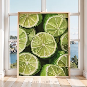 May include: A framed print featuring a close-up of sliced limes. The artwork showcases vibrant green and white citrus fruit against a dark green background. The print is displayed in a light brown wooden frame, with the text "MY PRINTABLE JOY" at the bottom.