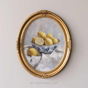 May include: A painting of lemons in a blue and white bowl, set on a white tablecloth. The painting is framed in a gold ornate frame.