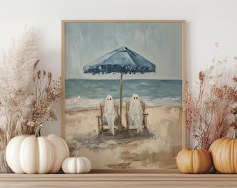 May include: A framed art print depicts two ghosts relaxing on beach chairs under a blue umbrella. The artwork, with a beach scene background, has a light blue sky and ocean. The print is displayed on a wooden mantel with pumpkins and dried plants.