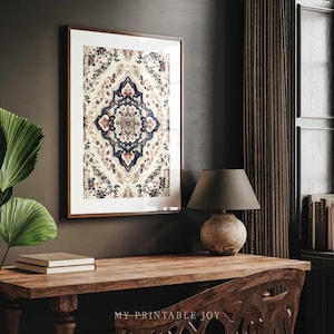 May include: A framed print of a colorful, intricate mandala design with a white background. The print is hanging on a dark gray wall above a wooden desk with a lamp and books.