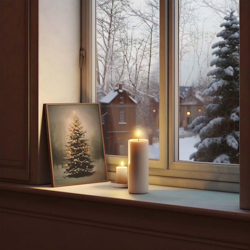 Peut inclure: Une impression encadr&eacute;e d'un sapin de No&euml;l recouvert de neige avec des lumi&egrave;res, pos&eacute;e sur un rebord de fen&ecirc;tre avec deux bougies allum&eacute;es. La fen&ecirc;tre donne sur une sc&egrave;ne hivernale enneig&eacute;e.