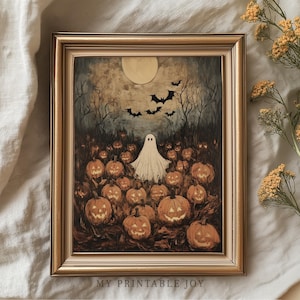 May include: A framed Halloween-themed print featuring a ghost in a field of carved pumpkins under a full moon. Bats fly in the night sky above the ghost and pumpkins. The frame is gold-colored, and the text "MY PRINTABLE JOY" is at the bottom.
