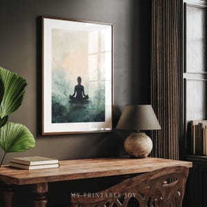 May include: A framed print of a watercolor painting depicting a person sitting in a meditative pose with a soft, ethereal background of blue and green hues.