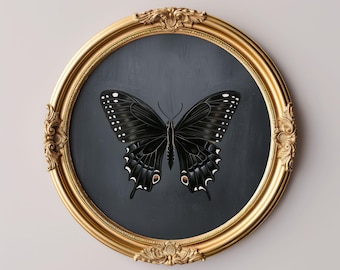 May include: A framed print featuring a black butterfly with white and red accents, set against a dark gray background. The artwork is enclosed in a gold, ornate, oval frame. The text "MY PRINTABLE JOY" is at the bottom.
