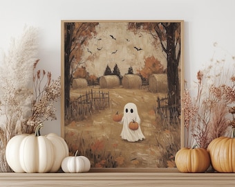 Könnte beinhalten: Ein gerahmter Halloween-Druck zeigt einen Geist mit Kürbissen, der einen Weg durch ein Feld mit Heuballen entlanggeht. Das Kunstwerk verwendet eine gedämpfte Farbpalette aus Braun-, Orange- und Beigetönen, mit Fledermäusen am Himmel. Dekorative Kürbisse liegen auf einer Holzoberfläche.