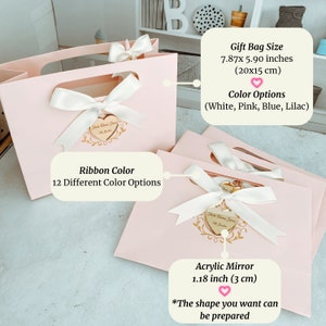 May include: Pink gift bags with white ribbon bows and a gold heart-shaped acrylic mirror with the text "Hola Welcome Home" and "With Love". The bags are 7.87 x 5.90 inches (20 x 15 cm). The ribbon colour can be customised in 12 different colours. The mirror is 1.18 inches (3 cm) and the shape can be customised.