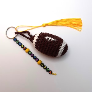 Porte-clé "ballon de rugby" ou "Ballon de basket" avec message ou prénom en perles et son pompon à frange réuni sur un anneau argenté
