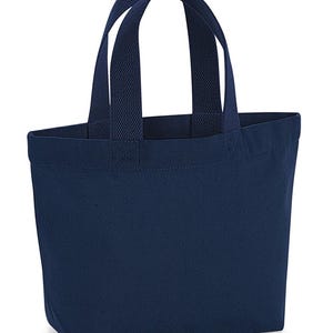 K&ouml;nnte beinhalten: Eine einfarbige, marineblaue Tragetasche aus Segeltuch mit zwei passenden Stoffhenkeln in strukturierter Webart. Die Tasche hat einen rechteckigen Boden und eine offene Oberseite, gefertigt aus strapazierf&auml;higem, blickdichtem Material mit sichtbaren N&auml;hten.