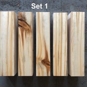 May include: Set of four unfinished wooden blocks, each measuring 13 inches in length. The blocks are arranged in a row and have a natural wood grain.