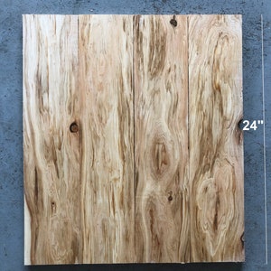 May include: Set of three wood planks, each measuring 22 inches by 24 inches and 11/16 inches thick. The wood has a natural, light brown color with a knot in the center of the top plank. The planks are arranged vertically, side by side.