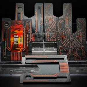 May include: A collection of black and red rectangular game card holders featuring a circuit board pattern. One holder displays a card with the text FIRE LOADING and BURN AT BOTH ENDS. The holders are arranged in a clear tiered display stand.
