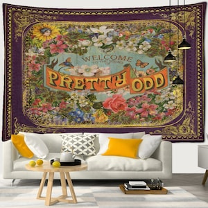 May include: A decorative tapestry with a purple border and gold detailing. The central design features a floral arrangement and the words "WELCOME TO THE SOUND OF PRETTY ODD" in orange. It is displayed on a wall.