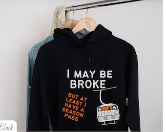 Puede incluir: Sudadera con capucha negra con texto blanco que dice "Puedo estar en bancarrota, pero al menos tengo un pase de temporada" y un gráfico de un telesilla con el texto "Lift Season".
