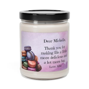 May include: A white candle jar with a black lid and a label that says "Dear Michelle, Thank you for making life a little more delicious and a lot more fun. Love: Allie". The label has a watercolor background with a stack of colorful macarons.