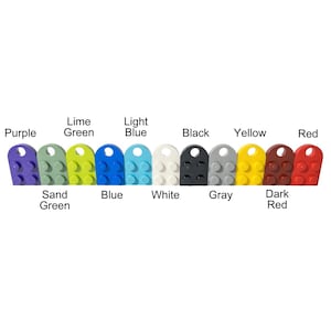 Puede incluir: Una fila de 10 ladrillos LEGO de diferentes colores, incluyendo morado, verde lima, azul claro, negro, amarillo, rojo, verde arena, azul, blanco y gris. Los ladrillos est&aacute;n dispuestos en una l&iacute;nea de izquierda a derecha.