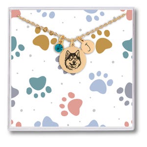 May include: Gold necklace with a paw print charm, a blue crystal charm, and a round charm with a dog silhouette and the letter J.