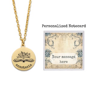 May include: Gold necklace with a round pendant featuring an open book with flowers and the name "anastasia" engraved on it. The necklace comes in a small box with a personalized notecard.
