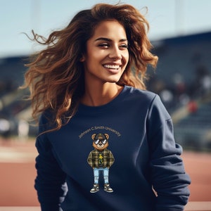 May include: A navy blue sweatshirt with a cartoon bear wearing sunglasses and a plaid shirt. The bear is holding a gold chain and has a gold chain around its neck. The text "Johnson C. Smith University" is printed on the sweatshirt.