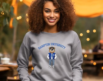 May include: Grey sweatshirt featuring a blue and white cartoon bear wearing sunglasses and a blue jacket with the text "Hampton University" above the bear.