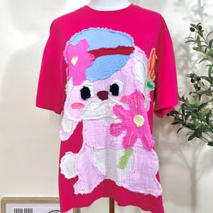Camiseta extragrande con apliques hechos a mano: adorable conejito con flor, dibujo animado de fantasía, suave algodón, corte holgado, pieza única.